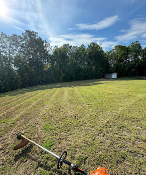 A lawn mower sitting on top of a grass covered field