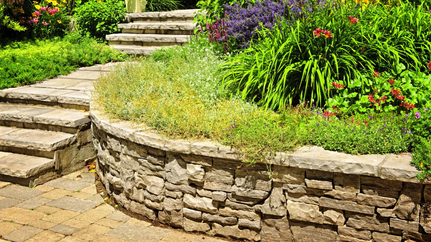 A stone garden wall with steps leading up to it